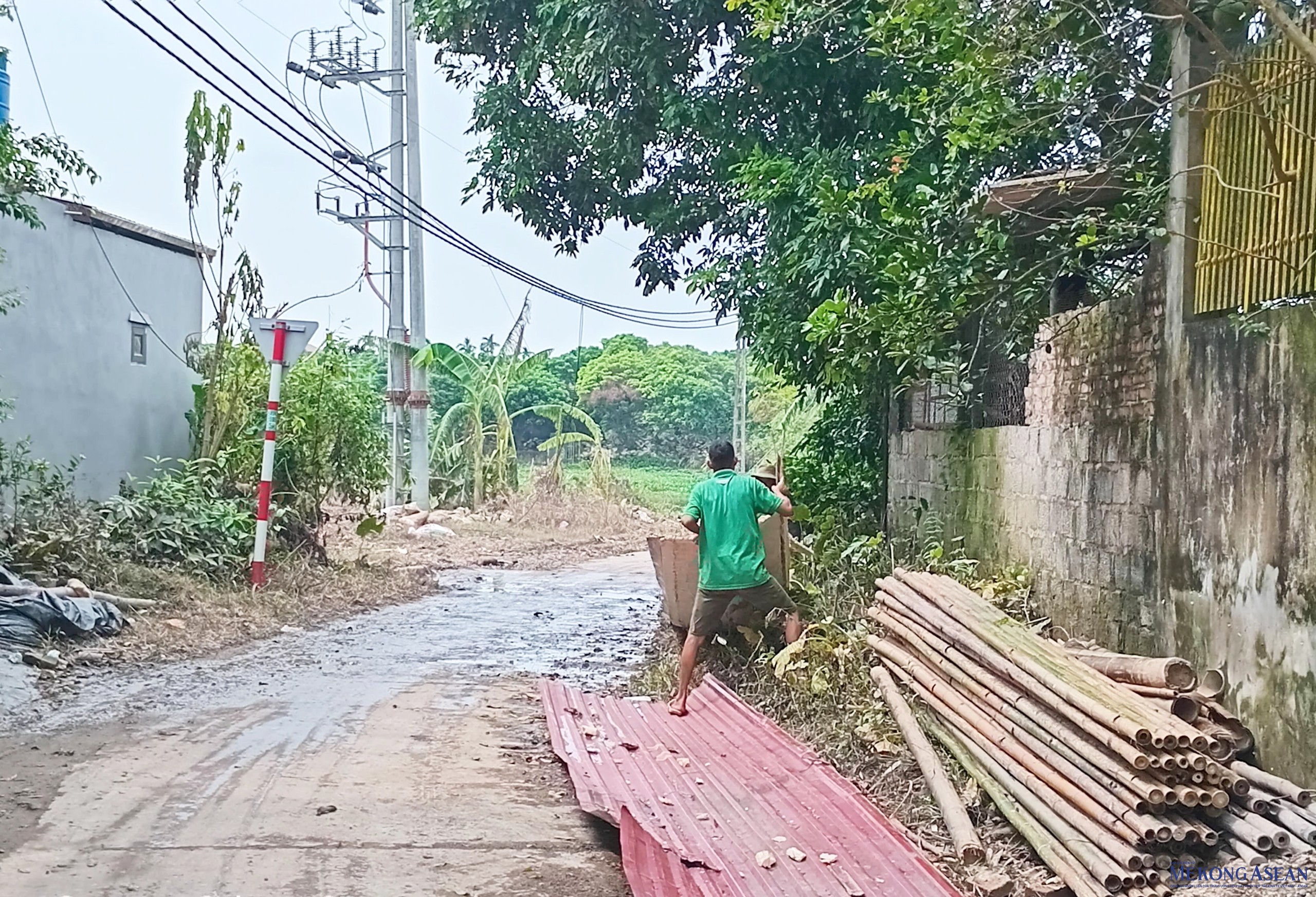 Người dân thành phố Hưng Yên (tỉnh Hưng Yên) dọn dẹp mái tôn, cành cây bị gãy đổ sau bão lụt. Ảnh chụp trưa 16/9.