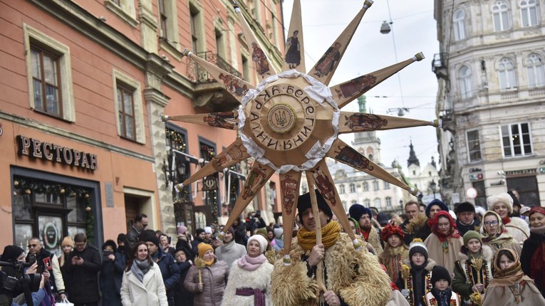 Người Ukraine h&aacute;t những b&agrave;i h&aacute;t mừng Gi&aacute;ng sinh, cầm ng&ocirc;i sao Bethlehem tại lễ hội Gi&aacute;ng sinh Ch&iacute;nh thống gi&aacute;o ở Lviv, ng&agrave;y 6/1/2022. Ảnh: AP