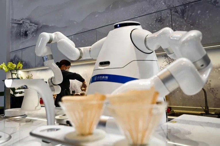 Robot pha c&agrave; ph&ecirc; v&agrave; phục vụ c&agrave; ph&ecirc; tại ga Taizicheng. Ảnh: Jewel Samad/AFP