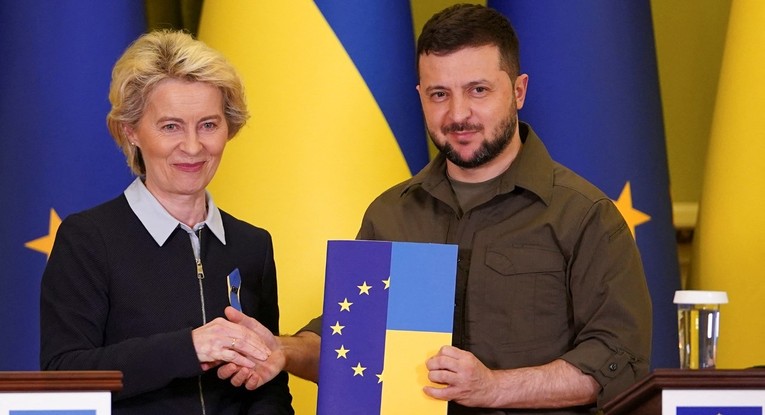 Chủ tịch Ủy ban ch&acirc;u &Acirc;u Ursula von der Leyen (tr&aacute;i) trao bảng c&acirc;u hỏi tư c&aacute;ch th&agrave;nh vi&ecirc;n cho Tổng thống Ukraine Volodymyr Zelensky, th&aacute;ng 4/2022. Ảnh: Reuters