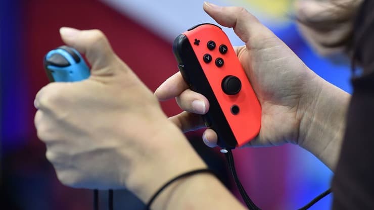 Kh&aacute;ch tham quan chơi tr&ograve; chơi điện tử Switch mới của Nintendo trong buổi giới thiệu tại Tokyo, Nhật Bản. Ảnh: AFP