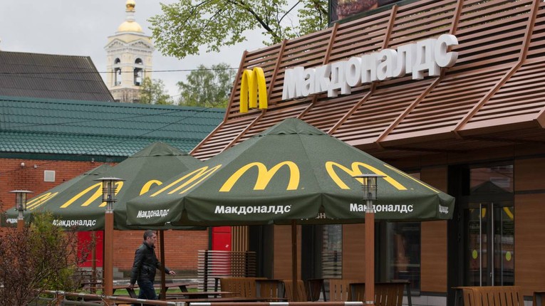 Một người đi qua cửa h&agrave;ng McDonald&amp;amp;amp;apos;s ở th&agrave;nh phố Podolsk, Nga. Ảnh: Bloomberg