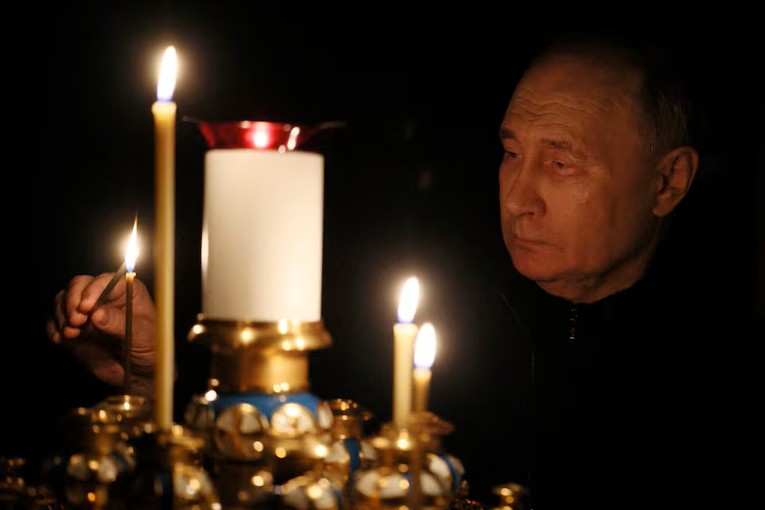 Tổng thống Nga Vladimir Putin thắp nến tưởng nhớ c&aacute;c nạn nh&acirc;n tại nh&agrave; thờ ở dinh thự bang Novo-Ogaryovo, ngoại &ocirc; Moscow, ng&agrave;y 24/3. Ảnh: Reuters