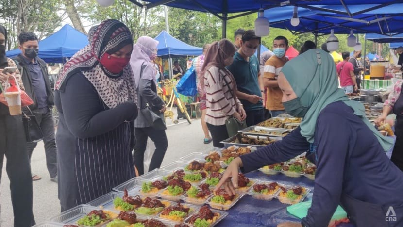 C&ocirc; Deltisusanti Suhardi (phải) đang b&aacute;n h&agrave;ng cho một kh&aacute;ch h&agrave;ng tại chợ Ramadan ở SS6, Petaling Jaya. Ảnh: CNA