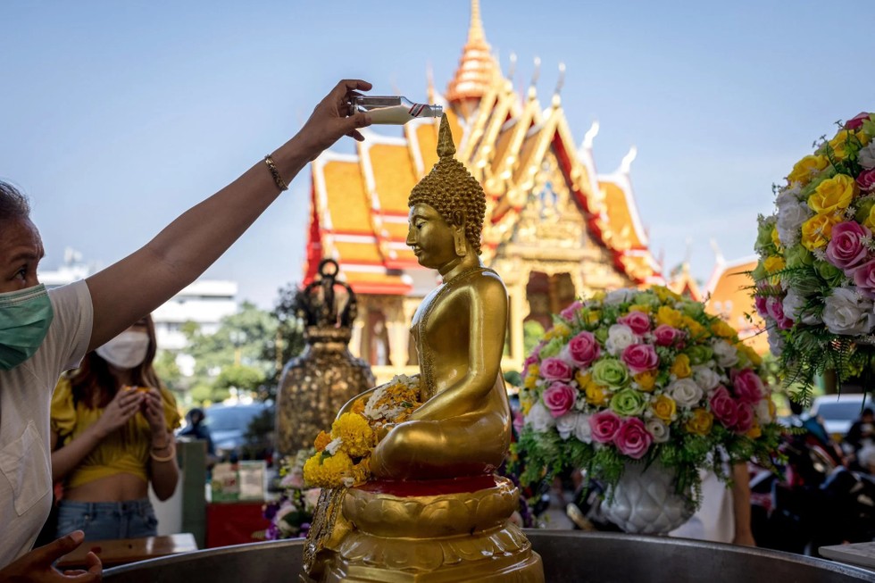 Một người thực hiện nghi thức tắm Phật tại đền Wat Mahabut tại Bangkok. Ảnh: AFP