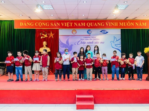 Hai bạn Đặng Vũ Ngọc Mai v&agrave; Đặng Vũ H&agrave; Ch&acirc;u c&ugrave;ng Hiệu trưởng Trường THCS Nguyễn Đ&igrave;nh Chiều trao phần qu&agrave; cho c&aacute;c bạn học sinh khiếm thị.