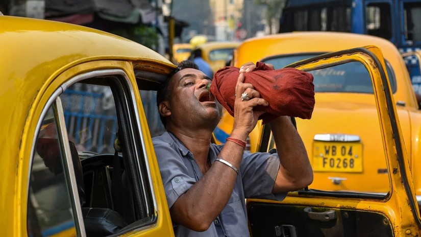 Một l&aacute;i xe taxi uống nước trong c&aacute;i n&oacute;ng buổi trưa ở Kolkata, Ấn Độ, ng&agrave;y 18/4. Ảnh: Getty Images