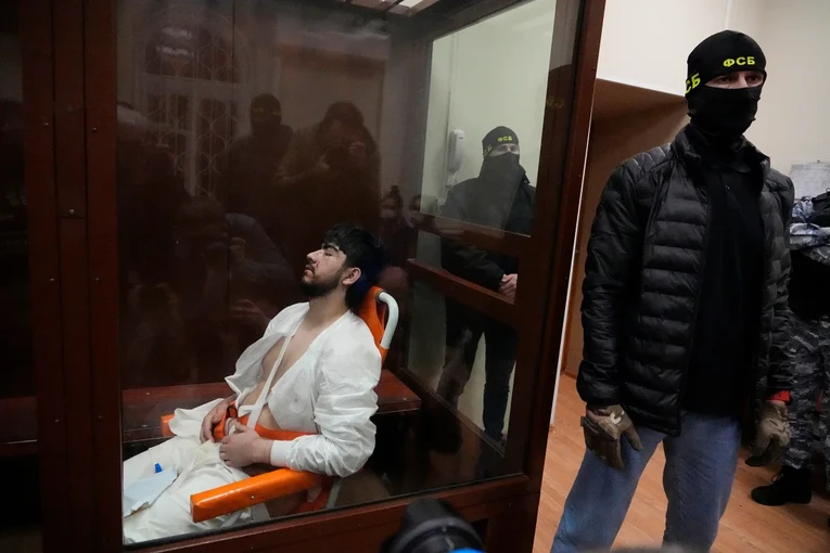 Muhammadsobir Fayzov, nghi phạm trong vụ xả s&uacute;ng ng&agrave;y 22/3, ngồi tr&ecirc;n ghế y tế đến T&ograve;a &aacute;n. Ảnh: Reuters