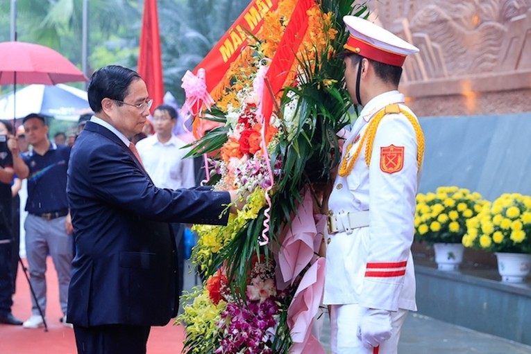 Thủ tướng Phạm Minh Ch&iacute;nh d&acirc;ng hoa tại Bức ph&ugrave; đi&ecirc;u B&aacute;c Hồ n&oacute;i chuyện với c&aacute;n bộ, chiến sĩ Đại đo&agrave;n qu&acirc;n Ti&ecirc;n Phong tại Ng&atilde; năm Đền Giếng. Ảnh: VGP