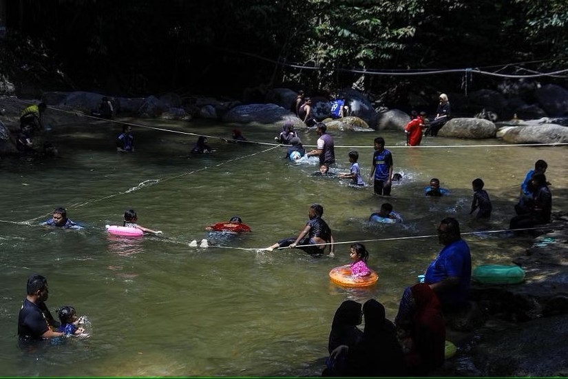 Người d&acirc;n tắm dưới s&ocirc;ng Kalumpang trong một ng&agrave;y nắng n&oacute;ng ở Tanjung Malim, Perak, Malaysia. Ảnh: EPA - EFE