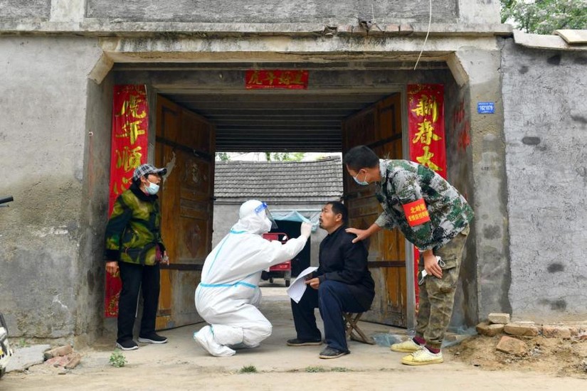 Một người d&acirc;n Trung Quốc đang được lấy mẫu x&eacute;t nghiệm Covid-19. Ảnh: AFP