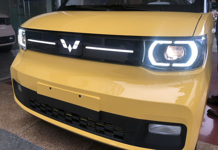 Biểu tượng logo Wuling v&agrave; dải trang tr&iacute; 2 b&ecirc;n dạng LED &acirc;m, c&oacute; thể ph&aacute;t s&aacute;ng tr&ecirc;n mặt ca-lăng đen b&oacute;ng. Ảnh: TMT Motors.