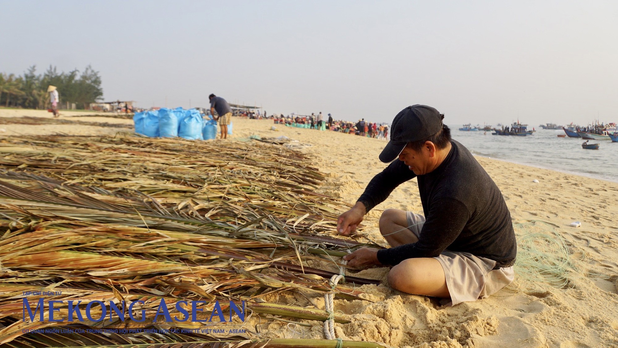 &Ocirc;ng Phạm Phong H&acirc;n (50 tuổi) đang d&ugrave;ng d&acirc;y thừng cột l&aacute; dừa th&agrave;nh ph&ecirc;n để chuẩn bị cho chuyến ra khơi tiếp theo. Người đ&agrave;n &ocirc;ng c&oacute; 30 năm kinh nghiệm đi biển cho biết, ph&ecirc;n l&aacute; dừa để tạo b&oacute;ng r&acirc;m, gi&uacute;p thu h&uacute;t c&aacute; v&agrave;o lưới nhiều hơn.