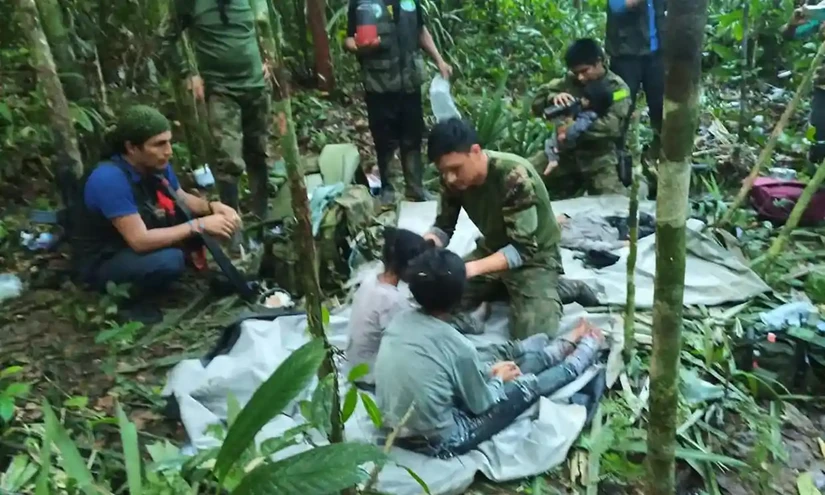 C&aacute;c binh sĩ chăm s&oacute;c 4 đứa trẻ sau khi ph&aacute;t hiện ch&uacute;ng trong rừng. Ảnh: Văn ph&ograve;ng Tổng thống Colombia