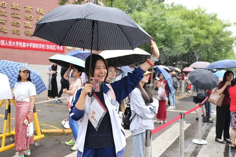 Một học sinh vẫy tay ch&agrave;o tạm biệt cha mẹ trước khi bước v&agrave;o địa điểm thi tại cơ sở Triều Dương của Trường Trung học trực thuộc Đại học Nh&acirc;n d&acirc;n tại Bắc Kinh ng&agrave;y 7/6/2024. Ảnh: China Daily