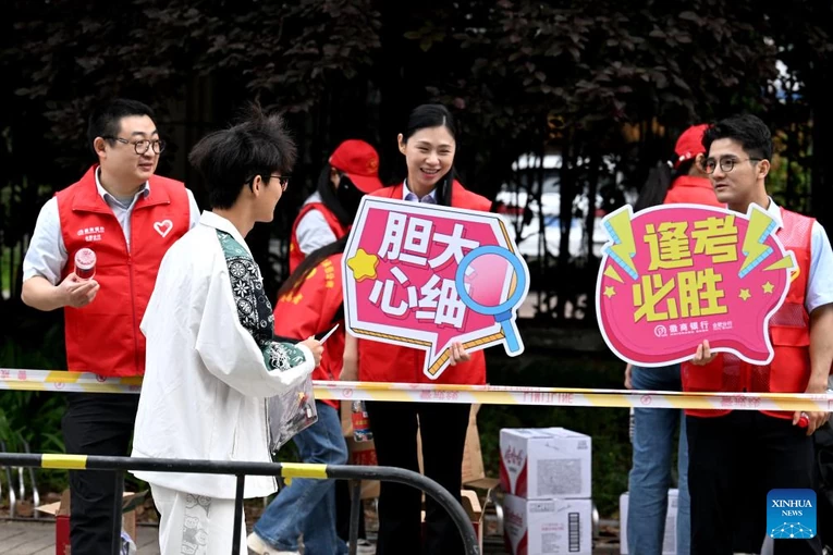 C&aacute;c t&igrave;nh nguyện vi&ecirc;n động vi&ecirc;n một th&iacute; sinh b&ecirc;n ngo&agrave;i địa điểm cao khảo ở Hợp Ph&igrave;, tỉnh An Huy ph&iacute;a đ&ocirc;ng Trung Quốc, ng&agrave;y 7/6/2024. Ảnh: T&acirc;n Hoa X&atilde;