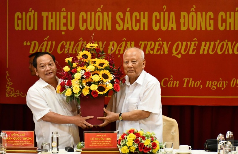 &Ocirc;ng L&ecirc; Phước Thọ (b&ecirc;n phải) nhận hoa ch&uacute;c mừng của B&iacute; thư Th&agrave;nh ủy Cần Thơ Trần Quốc Trung, nh&acirc;n buổi lễ giới thiệu s&aacute;ch &ldquo;Dấu ch&acirc;n in đậm tr&ecirc;n qu&ecirc; hương, đất nước&rdquo;, th&aacute;ng 9/2020. Ảnh: B&aacute;o Cần Thơ