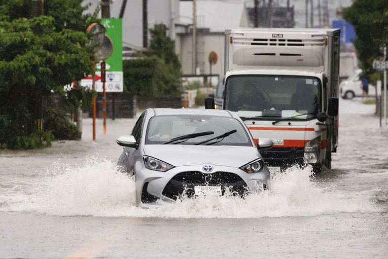 C&aacute;c phương tiện di chuyển tr&ecirc;n con đường ngập nước ở Kurume, tỉnh Fukuoka, ng&agrave;y 10/7. Ảnh: Kyodo