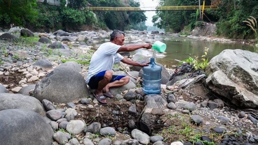 Người d&acirc;n t&igrave;m nước tại một con s&ocirc;ng ở l&agrave;ng Parakan Bujang, T&acirc;y Java, Indonesia. Ảnh: CNA