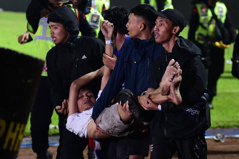 Một nạn nh&acirc;n được khi&ecirc;ng ra khỏi s&acirc;n b&oacute;ng sau vụ bạo loạn. Ảnh: AFP