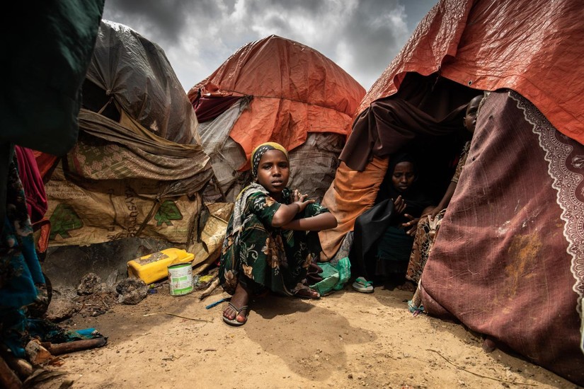 Một b&eacute; g&aacute;i ngồi b&ecirc;n ngo&agrave;i căn lều d&agrave;nh cho những người di tản ở Mogadishu, Somalia, th&aacute;ng 10/2022. Ảnh: UNICEF