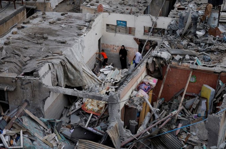 Người Palestine kiểm tra thiệt hại tại địa điểm Israel tấn c&ocirc;ng ở Khan Younis, Gaza. Ảnh: Reuters