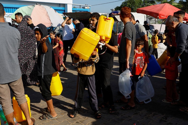 Người Palestine xếp h&agrave;ng lấy nước tại một trung t&acirc;m do Li&ecirc;n Hợp Quốc điều h&agrave;nh ở Khan Younis. Ảnh: Reuters