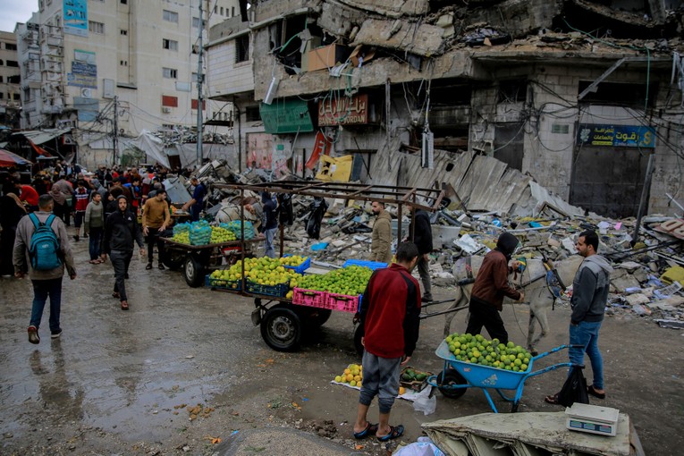 Người Palestine b&aacute;n rau trước một t&ograve;a nh&agrave; bị ph&aacute; hủy ở th&agrave;nh phố Gaza, ng&agrave;y 27/11. Ảnh: AFP